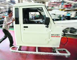 An employee pushes the frame of the cabin of a Mahindra Bolero vehicle at the company's manufacturing plant near Mumbai.