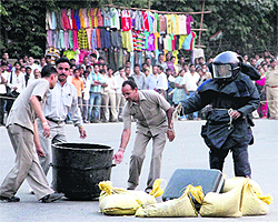 A bomb disposal squad inspects an abandoned briefcase near Lanse Down Chowk in Dehradun on Wednesday