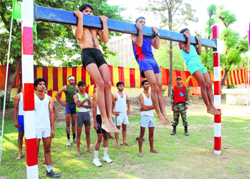Aspirants take part in the chinning exercise during the Army recruitment rally in Kurukshetra on Wednesday. Tribune photo: Ravi Kumar