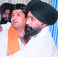 Senior Deputy Mayor and SAD candidate from Ward 45 Kamaljit Bhatia hugs Congress candidate Gulshan Kumar, who withdrew his papers for contesting MC elections, in Jalandhar on Wednesday