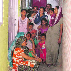 Neighbours gather outside the house of Sheelo, whose daughter and son-in-law died in an accident near Srinagar on Wednesday. 