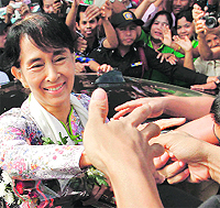 Aung San Suu Kyi greets migrant workers from Myanmar, in Thailand on Wednesday
