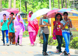 Students use umbrellas to protect themselves from the scorching sun on the Kurukshetra University campus in Kurukshetra.