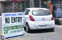 A car enters a prohibited zone in spite of a road sign restricting the entry of vehicles in Jammu. Tribune photo: Anand Sharma 