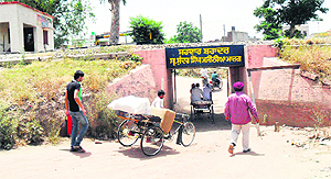 Commuters use a mud path under the railway crossing at Jodda Phatak, which remain closed for a long period of the day, in Ward 28 in Amritsar