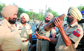 Police officials examine the shell found near the Sirhind Canal in Bathinda on Saturday.