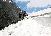 Workers clear snow from a track to be used for the Amarnath pilgrimage