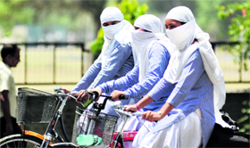 Girls cover their face with dupattas to beat the heat in Ludhiana.