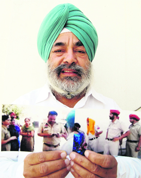 Majithia shows photographs of the raid at his ancestral home to the media in Amritsar on Sunday.