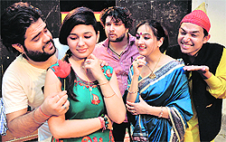 Artistes enact a scene from a play Intzaar at Natrang Theatre in Jammu on Sunday