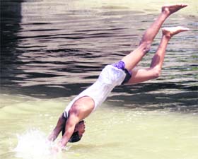 A boy dives into a river on a hot summer afternoon in Amritsar on Monday