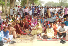 Protesting teachers sitting on a dharna on the Bathinda-Barnala road while one of the protesters 