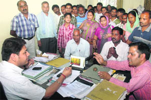 Residents of Morowala village complain against inadequate power supply to an executive engineer in Dehradun on Monday. 