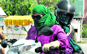 Girls cover their faces to protect themselves from the scorching sun in Gurgaon.