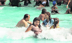 People beat the heat by playing in a water park in Jalandhar on Monday. Photo: Sarabjit Singh
