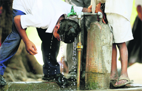 A boy tries to beat the scorching heat in Ludhiana by going under a tap on Monday.