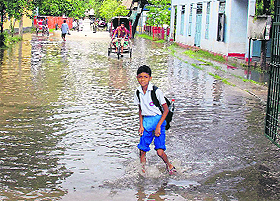  A boy walks through a water-logged road in Guwahati after 