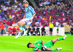 Spain's Fernando Torres (L) jumps over Chinas goalkeeper Zeng Cheng during their friendly match leading up to Euro 2012 in Seville on Sunday.  Reuters