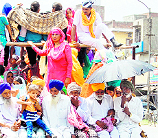 Visitors try to save themselves from the sun on their way back after a visit to the holy city