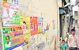 Posters of candidates pasted on a wall in violation of the election code in Patiala.