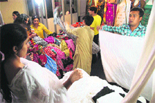 Visitors take a look at clothes on display at a Tourism Mart in Shimla. 