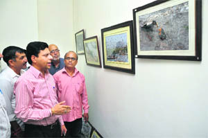 Deputy Commissioner Sanjeev Verma looks at photographs after inaugurating an exhibition on Tuesday. 