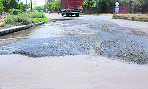 Pipe bursts, authorities unmoved: The view of a road stretch carpeted recently, which has been damaged due to the accumulation of water, at Phase II of the Industrial Area in Chandigarh.