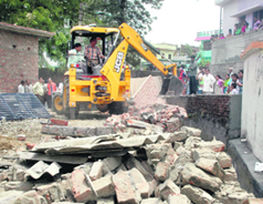 An encroachment being demolished by the Dehradun Municipal Corporation in the Suman Nagar area in Dehradun on Wednesday.