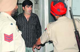 Travel agent Sandeep Ohri, owner of OGIC Immigration Consultants, being taken to a court by the police in Jalandhar on Wednesday