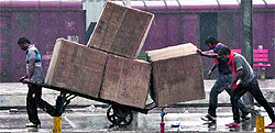 Men carrying parcels for unloading at the railway station in Ludhiana on Wednesday