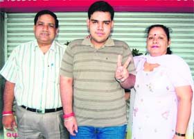 Ankur Popli, a student of Sant Sukha Singh Khalsa Senior Secondary School celebrate his success in Amritsar on Thursday