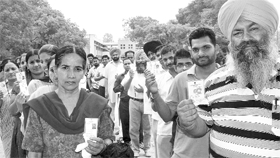Exercising their right Residents line up outside polling booths in Ropar on Thursday.