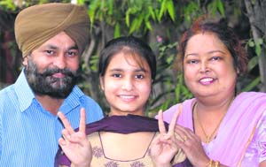 Charandeep Kaur and Bharti (right), who have been ranked 15th and 20th in the merit list, with their families in Jalandhar on Thursday