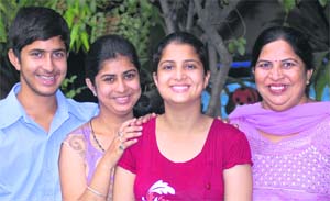 Charandeep Kaur and Bharti (right), who have been ranked 15th and 20th in the merit list, with their families in Jalandhar on Thursday