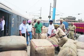 Excise officials and policemen try to lift parcels from the Ludhiana railway station