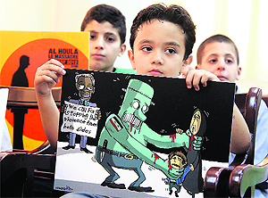 Lebanese children hold signs during a news conference at the Lebanese press syndicate in Beirut on Thursday. The conference was organised by the children of peace committee to protest the killing of children in Syria.