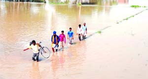Villagers make their way through the fields submerged under canal water. 