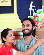 Amrinder Singh, who has secured 79 per cent in Class XII examination conducted by the PSEB, gets a hug from his mother in Chandigarh on Friday
