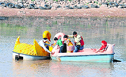 A CITCO employee tries to push a boat that got stuck in the centre of Sukhna Lake due to low water level on Friday