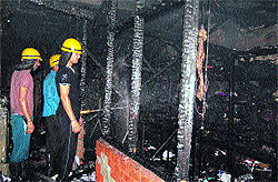 Firemen douse flames at a showroom in Sector 15, Panchkula, on Friday