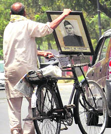 A man carries the framed photograph of Punjabs first Governor CM Trivedi (15-8-1947 to 10-3-1953) to the Punjab Governors House on a cycle in Chandigarh on Friday. 
