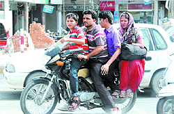 A family of four ride a motorcycle on the crowded Mall Road in Bathinda on Saturday