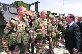 French President Francois Hollande (R) reviews troops during a visit to a military base in Kapisa, where most French troops are stationed in Afghanistan. 