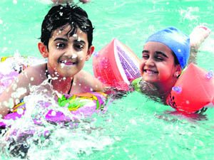 Kids enjoy in a pool during a summer camp in Dehradun on Sunday.