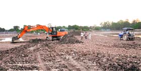 A JCB machine and a tractor being used to desilt the Sukhna Lake in Chandigarh on Monday