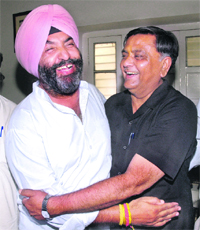 Former Local Bodies Minister Manoranjan Kalia hugs former Congress councillor Mohinder Singh Gullu during an annoucement by the latter of support to the BJP by his wife Kamaljeet Kaur