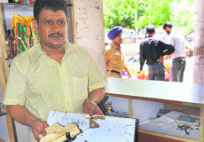 A worker shows the broken cash box at the liquor vend in Sector 22 of Chandigarh on Tuesday. 