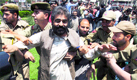 Policemen detain a senior Hurriyat leader during a protest in Srinagar on Tuesday.