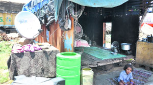 A child sits in front of his scrap-truck house at Transport Nagar in Jammu. 