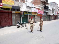 Police personnel patrol a deserted market in Bathinda on Wednesday. Various social and religious organisations imposed a bandh in the city to protest against the alleged slaughtering of cows at a bone grinding factory in Joga, Mansa.